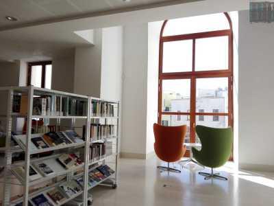 Molto gettonate sono le due poltrone, una arancione e l'altra verde, posizionate davanti a una finestra con vista sulla piazza sottostante...